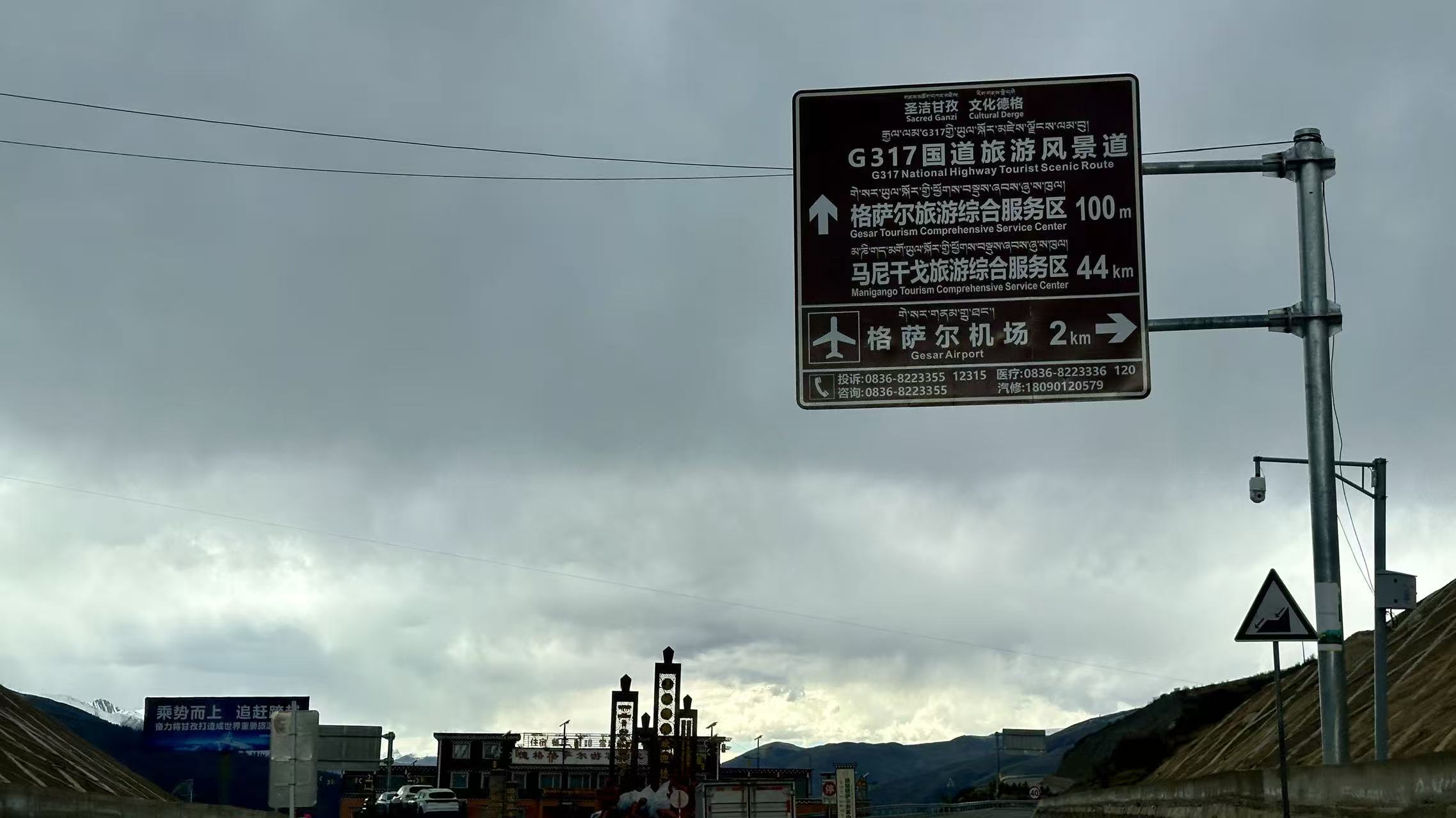 路上的真实路牌（格萨尔机场 2 km / 马尼干戈 44 km）